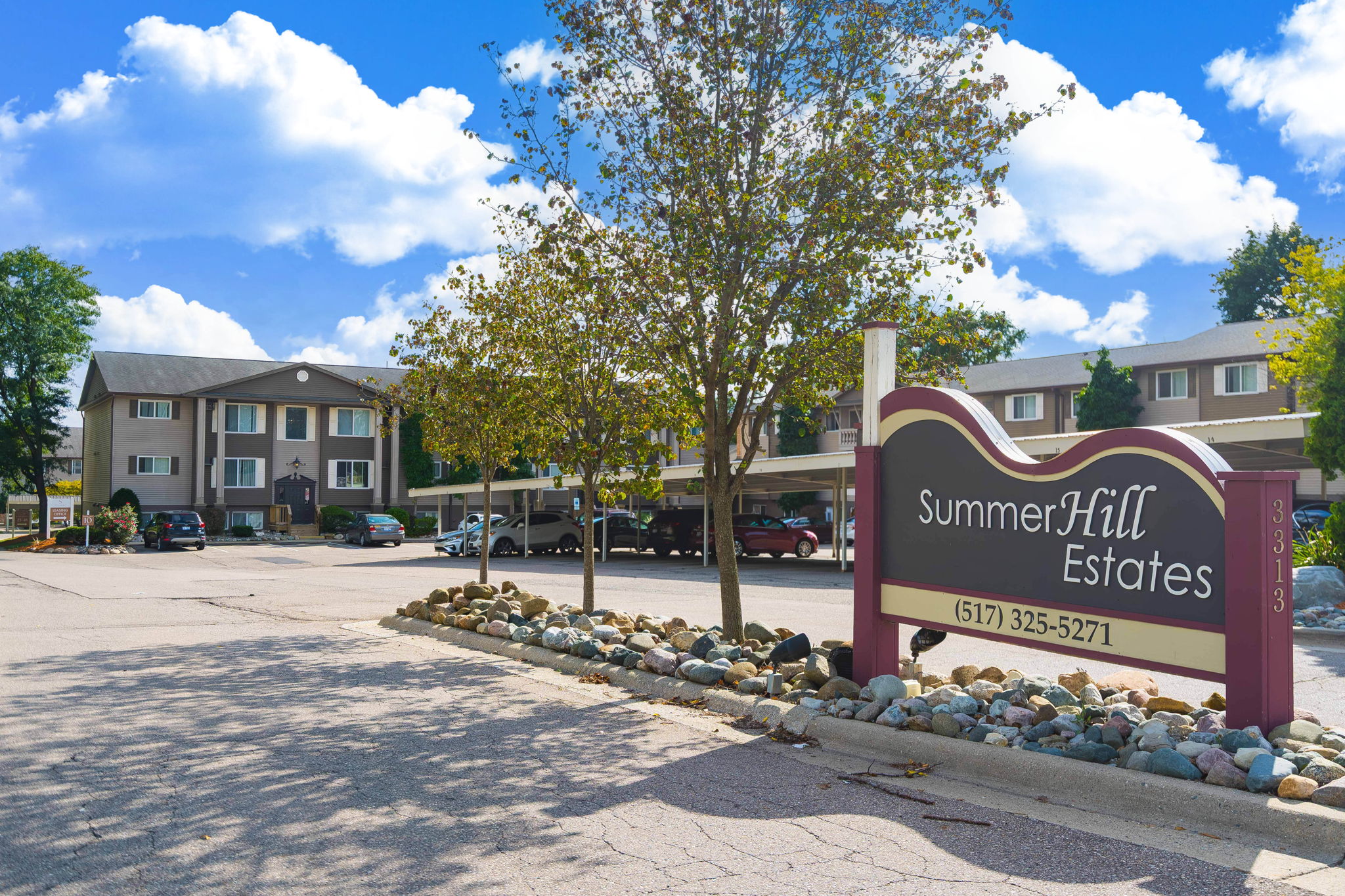 A sign for Summer Hill Estates is in front of a building.